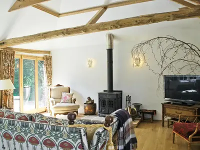 a living room with a couch and a wood stove at The Coach House in Saxmundham