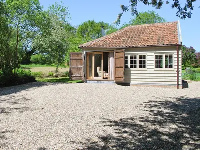 a small house with a large gravel driveway at The Coach House in Saxmundham