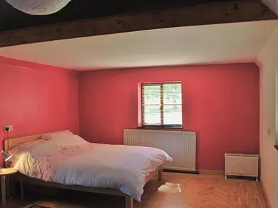 a red bedroom with a bed and a window at Burnt House Cottage in Barking