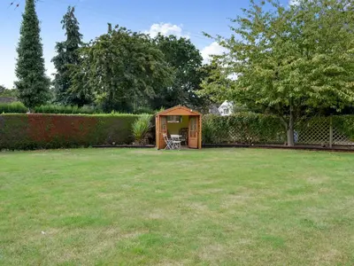 a small shed in a yard with a lawn at The Mount in Boxford
