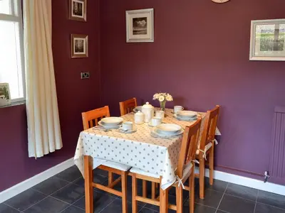 a dining room with a table with chairs and purple walls at The Mount in Boxford