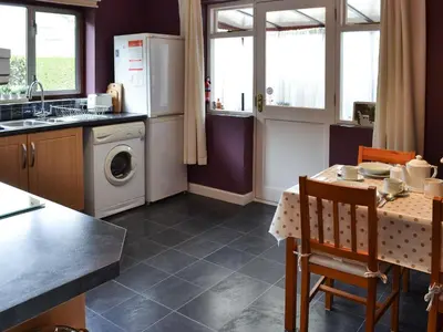 a kitchen with a table and a washing machine at The Mount in Boxford