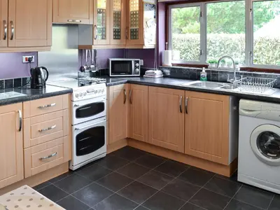 a kitchen with wooden cabinets and white appliances at The Mount in Boxford