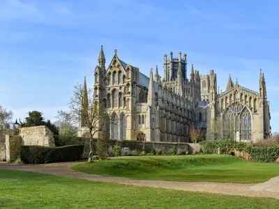a large stone building with a green lawn in front at The Lodge in Withersfield