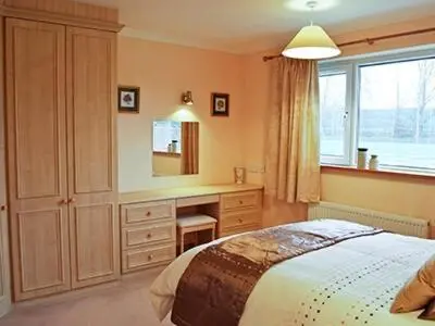 a bedroom with a bed and a desk in it at The Lodge in Withersfield