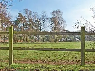 a wooden fence in the middle of a field at Nightingales in Hollesley