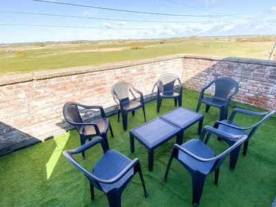 a group of chairs and tables and a brick wall at Mariners Lodge in Felixstowe