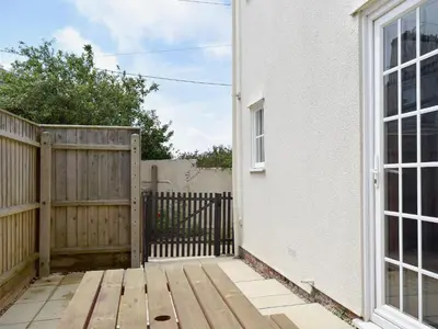 a wooden deck next to a house with a wooden gate at Mariners Lodge in Felixstowe