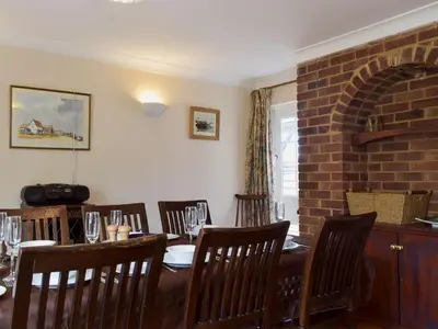 a dining room with a table and chairs and a brick wall at Mariners Lodge in Felixstowe