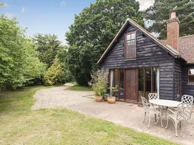a cottage with a table and chairs in the yard at Coach House in Melton