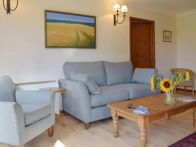 a living room with two blue couches and a coffee table at Coach House in Melton