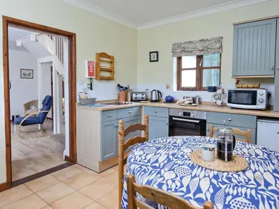 a kitchen with a table and a dining room at Coach House in Melton