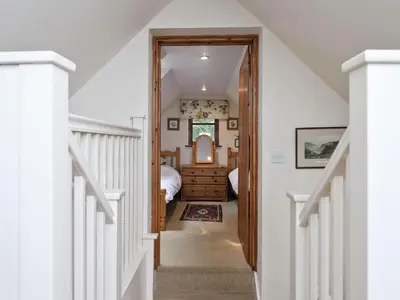 a hallway leading to a bedroom with a bed at Coach House in Melton