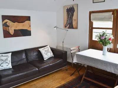a living room with a black leather couch and a table at Stoker Loft in West Mersea