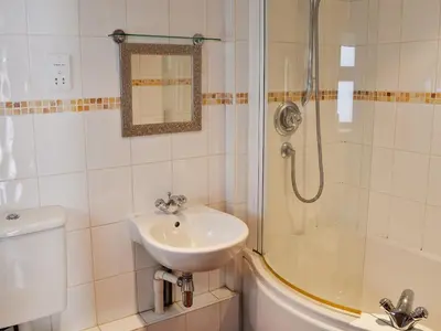 a bathroom with a sink and a shower at Stoker Loft in West Mersea