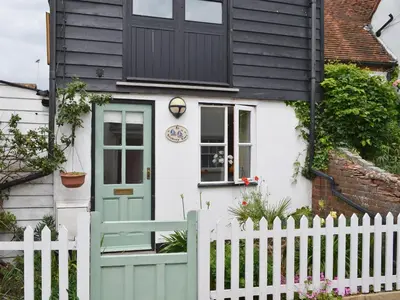a white house with a black roof and a green door at Stoker Loft in West Mersea