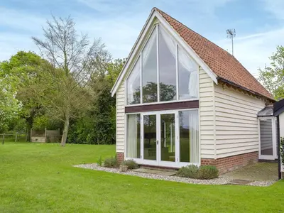 a house with large windows and a lawn at The Glass Room in Dedham