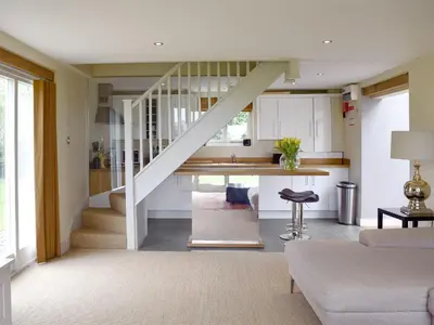 a kitchen and living room with a staircase in a house at The Glass Room in Dedham