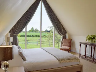 a bedroom with a bed and a large window at The Glass Room in Dedham