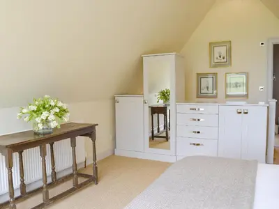 a room with white cabinets and a table with flowers on it at The Glass Room in Dedham