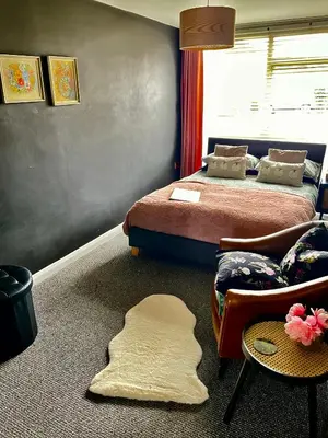 a bedroom with two beds and a rug on the floor at The Big Slepe in St Ives