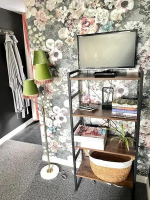 a television on a shelf with two green lamps at The Big Slepe in St Ives