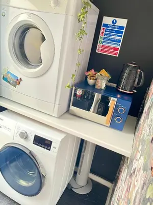 a washing machine sitting on a shelf with a microwave at The Big Slepe in St Ives