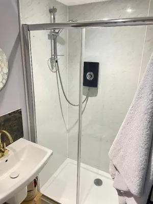 a shower with a glass door next to a sink at The Big Slepe in St Ives