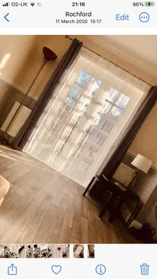 a room with a large window with a chair and a table at Ac lounge36 Room B in Rochford
