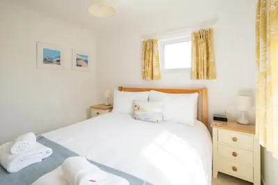 a bedroom with a white bed and a window at Annie's House in Thorpeness