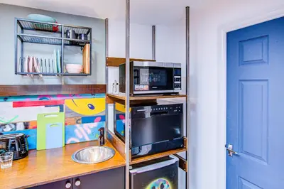 a kitchen with a counter with a microwave and a sink at Cosy Studio flat near hospital - Pass the Keys in Westcliff On Sea
