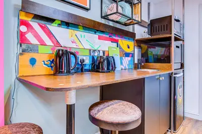 a bar in a kitchen with a counter and a stool at Cosy Studio flat near hospital - Pass the Keys in Westcliff On Sea