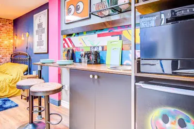 a kitchen with a counter and a bar with stools at Cosy Studio flat near hospital - Pass the Keys in Westcliff On Sea