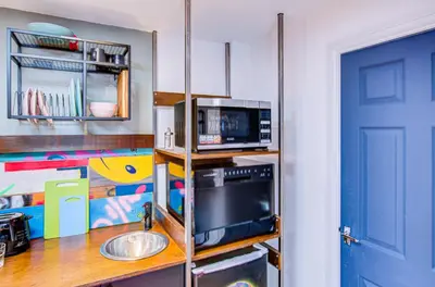 a kitchen with a sink and a tv on a shelf at Cosy Studio flat near hospital - Pass the Keys in Westcliff On Sea