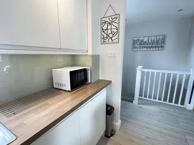 a microwave sitting on top of a counter in a kitchen at Luxurious apartment just off Mill Rd, near station - walk to historic city centre in Cambridge