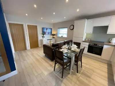 a kitchen and dining room with a table and chairs at Luxurious apartment just off Mill Rd, near station - walk to historic city centre in Cambridge