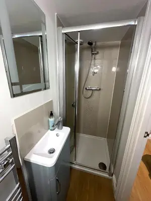 a white bathroom with a shower and a sink at City Studio - very best Location For exploring Cambridge - walk to station and City Centre in Cambridge