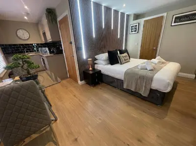 a bedroom with a large bed and a kitchen at City Studio - very best Location For exploring Cambridge - walk to station and City Centre in Cambridge