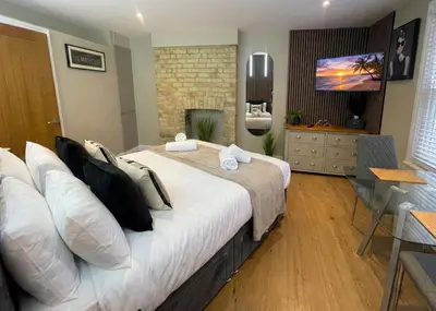 a bedroom with a large bed and a television at City Studio - very best Location For exploring Cambridge - walk to station and City Centre in Cambridge