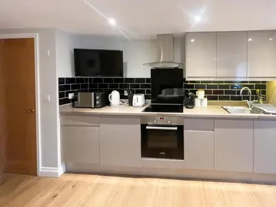 a kitchen with white cabinets and a stove top oven at Luxury Apartment with king-size Bed in Central Cambridge - easy walk to Station and City Centre in Cambridge