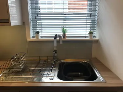 a kitchen with a sink and a window with plants at Luxury City CB1 Studio Just Off Mill Rd - Walk to Station and City Centre in Cambridge