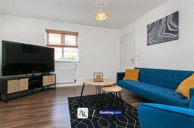 a living room with a blue couch and a tv at Stylish House By AR Properties Short Lets & Serviced Accommodation Colchester in Colchester
