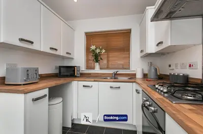 a kitchen with white cabinets and a counter top at Stylish House By AR Properties Short Lets & Serviced Accommodation Colchester in Colchester