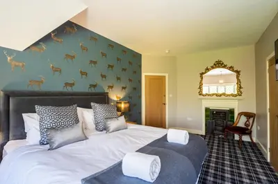 a bedroom with a bed and a wall with deer mural at Kettleburgh Chequers in Kettleburgh