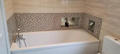 a white bath tub in a bathroom with a tile wall at Loughton 3 Bedroom Sleeps 5 by BSE Homes in Loughton
