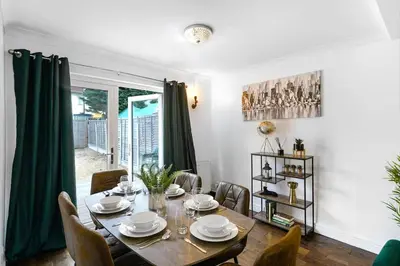 a dining room with a table and chairs at Loughton 3 Bedroom Sleeps 5 by BSE Homes in Loughton