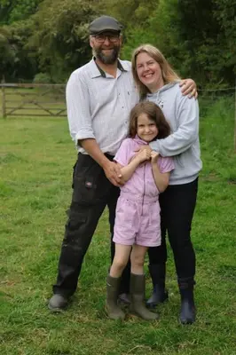 a man and a woman standing next to a little girl at The Falgate Shepherd's Hut in Caston