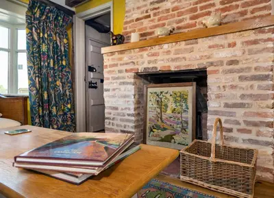 a living room with a brick fireplace with a table at Pats Place in Sudbury
