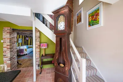 a staircase with a grandfather clock in a house at Pats Place in Sudbury