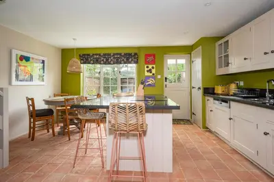 a kitchen with green walls and a counter with stools at Pats Place in Sudbury